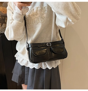 Gros plan sur le sac sous le bras en cuir PU noir brillant avec double poches et boucles