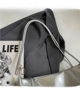 Detailed view of silver metallic shoulder bag with slim double top handles and sleek finish