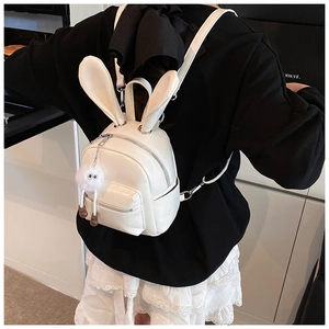 Close-up of a white mini backpack with bunny ears and a plush charm detail