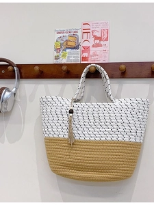 Handwoven straw tote bag in two-tone white and yellow with tassel and wooden bead charm