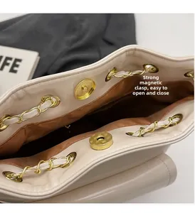 Dettaglio della borsa a secchiello con chiusura magnetica e catena dorata lucida