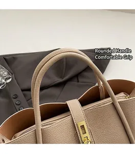 Dettaglio dei manici tondi e della chiusura dorata sulla borsa beige in pelle