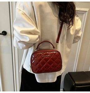 Vue détaillée du sac bandoulière en cuir matelassé rouge vin et détails dorés