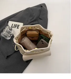 Vista interna della borsa a secchiello beige con coulisse e grande capacità quotidiana