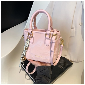 Pink marbled handbag with double handles and black braided charm in a lifestyle setting