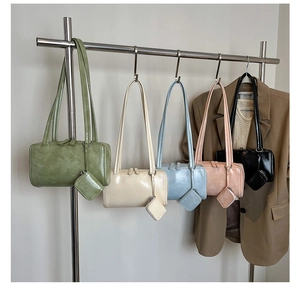 Row of minimalist shoulder bags in multiple colors with matching mini coin pouches