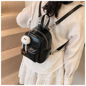 Mini black backpack in glossy PU leather with cute plush toy pendant on straps