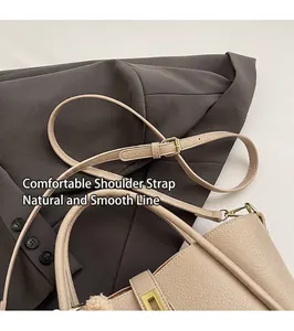 Dettaglio borsa beige in pelle martellata con fibbia dorata e ciondolo di peluche