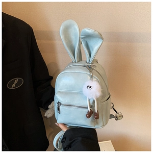 Detail of mint green mini backpack with rabbit ears and plush toy pendant