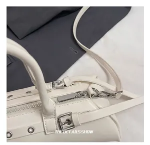 Primer plano de los herrajes plateados y cremallera de bolso blanco estilo almohada