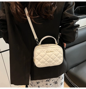 Détails du sac matelassé blanc avec logo métallique doré et poignée élégante