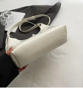 Detailed side view showing the smooth texture and structured base of the white shoulder bag