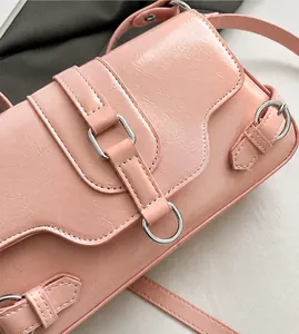 Close-up of pink PU leather shoulder bag with metallic rings and soft textured flap