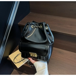 Détail du sac à dos seau en cuir noir avec chaîne dorée et cordon de serrage