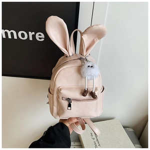 Detailed view of pink backpack featuring cute 3D bunny ears and a plush monster charm