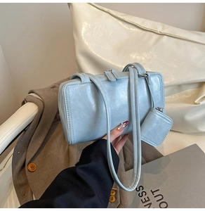 Detailed close-up of light blue faux leather shoulder bag with matching mini coin purse