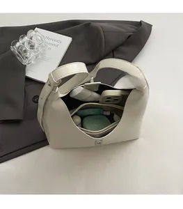 Interior view of white glossy leather crescent bag showing large capacity and zipper pocket