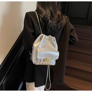 Détail du sac à dos seau argenté métallisé avec chaînes dorées porté par un mannequin