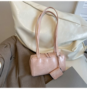 Macro detail of pink faux leather underarm bag with double zipper and small pouch