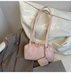 Detail of pink rectangular shoulder bag with vintage faux leather texture and coin purse