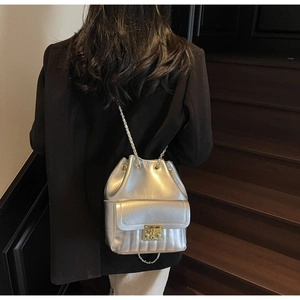 Détail du sac seau argenté métallisé avec texture matelassée et fermoir carré doré