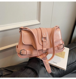 Détail du sac à bandoulière rose en cuir plissé brillant avec boucle en métal chic