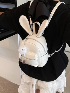 Mini white PU leather backpack with rabbit ears and plush charm shown on model