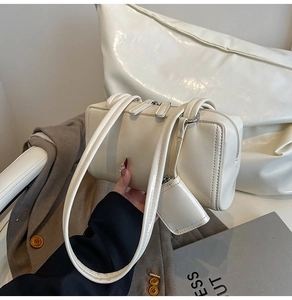 Detail of creamy white shoulder bag with smooth faux leather texture and mini coin purse