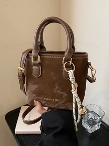 Chic brown PU leather bucket bag with fashion logo, gold hardware and bell charm pendant