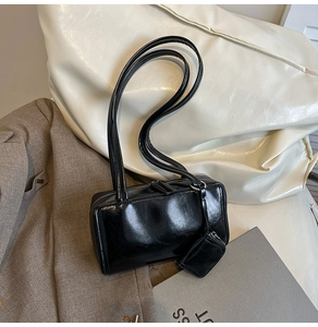 Detail of black glossy faux leather shoulder bag with small detachable zipper coin purse