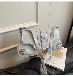 Détail du sac à bandoulière brillant bleu-gris clair avec boucles et finitions argentées