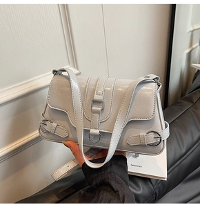 Gros plan d'un sac à bandoulière gris clair brillant avec boucles argentées élégantes