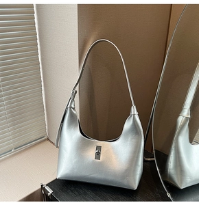 Detail of silver metallic hobo bag with adjustable strap and sleek metal twist lock