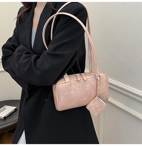 Close-up of pink pillow bag in matte leather featuring a small matching pendant charm