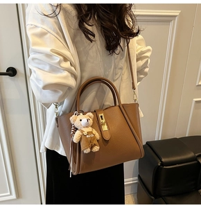 Borsa a mano marrone in pelle con ciondolo a forma di orsetto e chiusura a girello oro