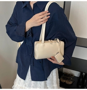 Detail of cream beige pillow shoulder bag with matching mini coin purse and twin straps