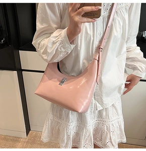 Detail of pink leather crescent hobo bag with silver metal swivel lock and adjustable strap