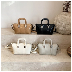 Detail view of stylish Boston bags in four colors on a minimalist stone display
