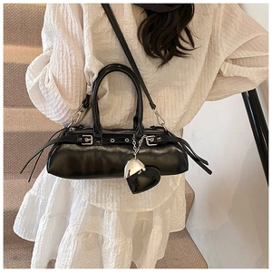 Detalle de bolso Boston negro con remaches plateados punk y colgante de corazón