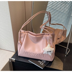 Close-up of pink PU leather tote bag with embossed MIKAXIQI logo and plush charm
