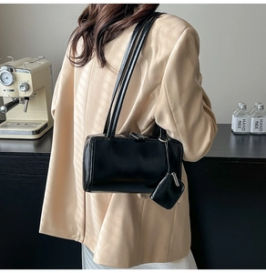 Detail of black glossy leather shoulder bag with matching coin purse on thin double straps