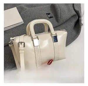 Close-up of cream Boston handbag with vertical double stitching and silver hardware