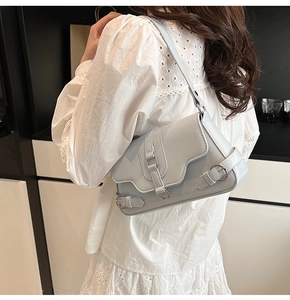 Détail du sac à bandoulière bleu clair en similicuir avec lanières et boucle argentée