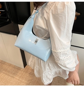 Detail of light blue hobo bag with silver twist lock shown on model wearing lace dress
