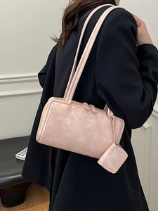 Minimalist beige leather shoulder bag with a small matching pouch and silver zipper detail