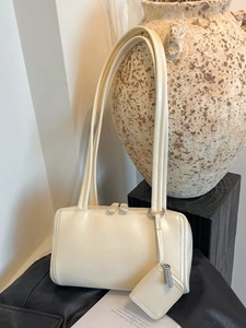 Minimalist beige underarm pillow bag with double straps and small hanging coin purse