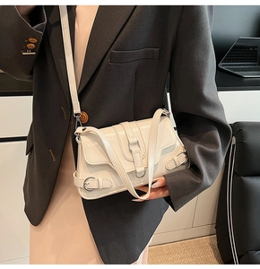 Détail d'un sac à bandoulière brillant beige crème avec boucles et rabat élégants