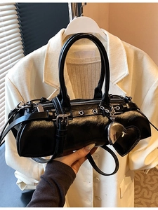 Bolso acolchado negro brillante con colgante de corazón y asas dobles fondo blanco