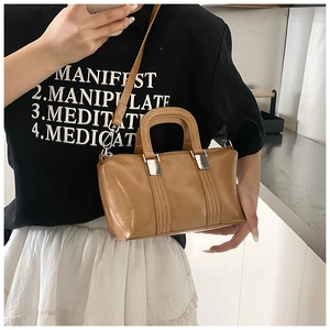 Close-up of caramel faux leather Boston bag with silver hardware and dual handles