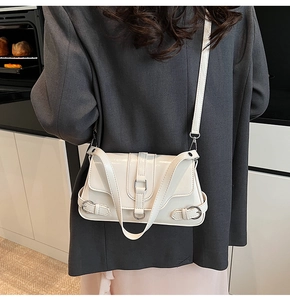 Détail du sac bandoulière en cuir PU crème avec boucles métalliques et rabat structuré